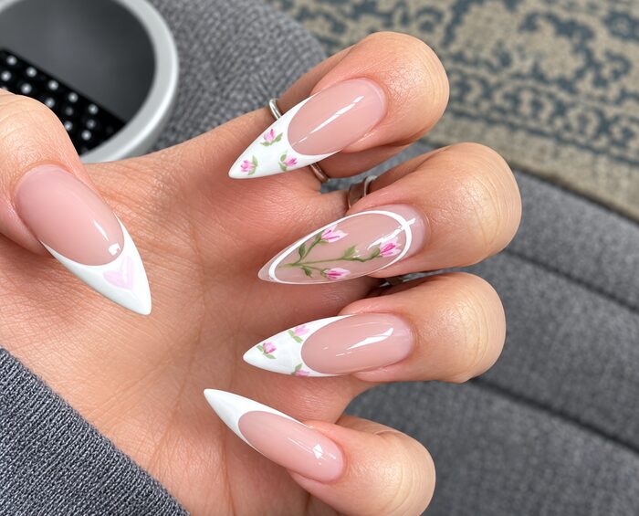 Long almond nails with white French tips and hand-painted pink tulips
